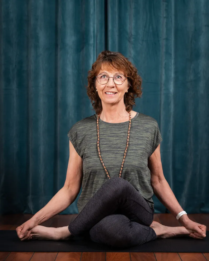 Eva Ekdahl, yogalärare i Stolsyoga, sitter på yogamattan i studion