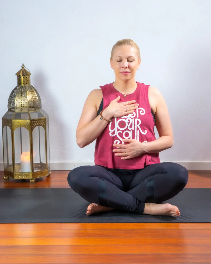 Lina Hammarstrand sitter i meditation på yogamattan i studion