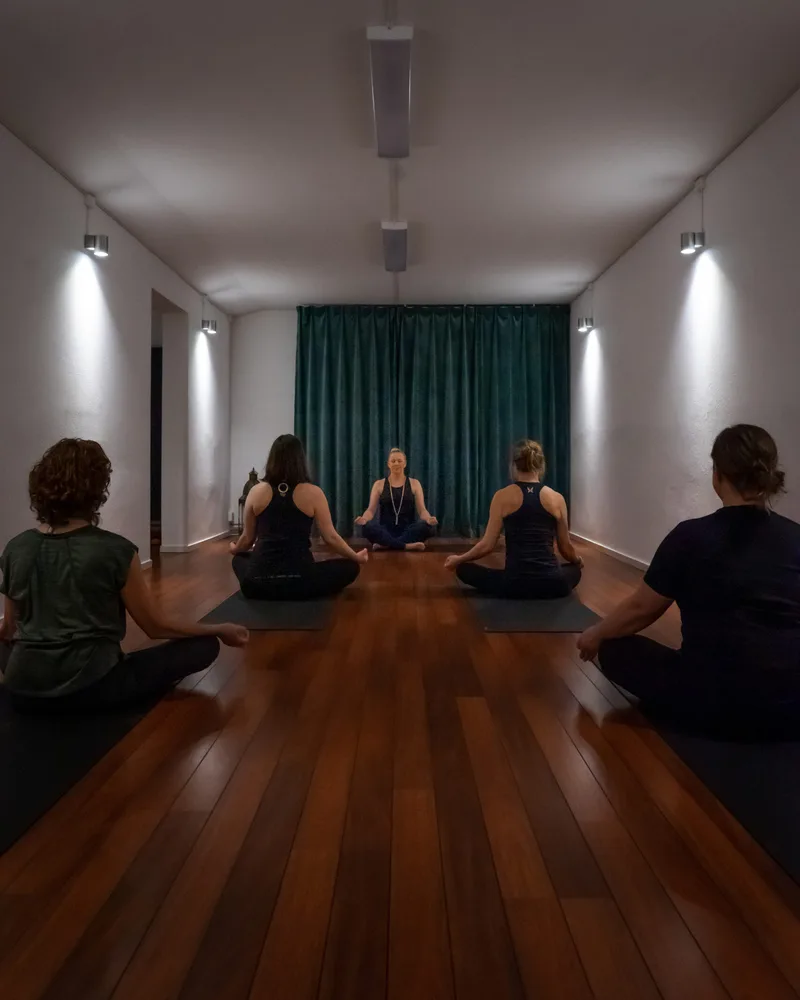 En yogaklass sitter i ring på trägolvet i yogastudion i Kolmården